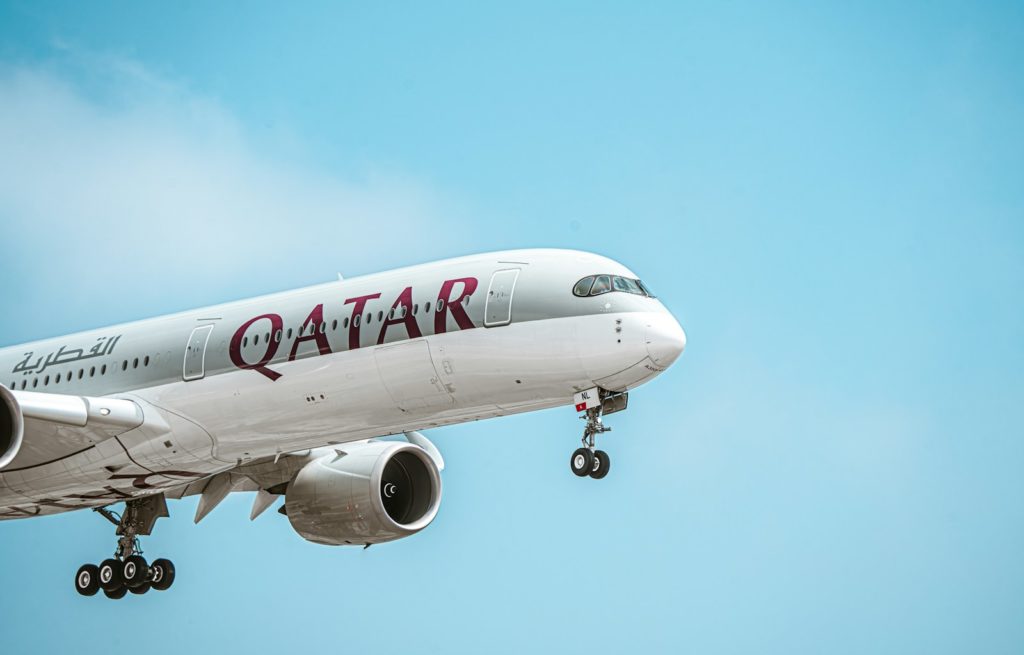 un grande aereo di linea che vola in un cielo blu